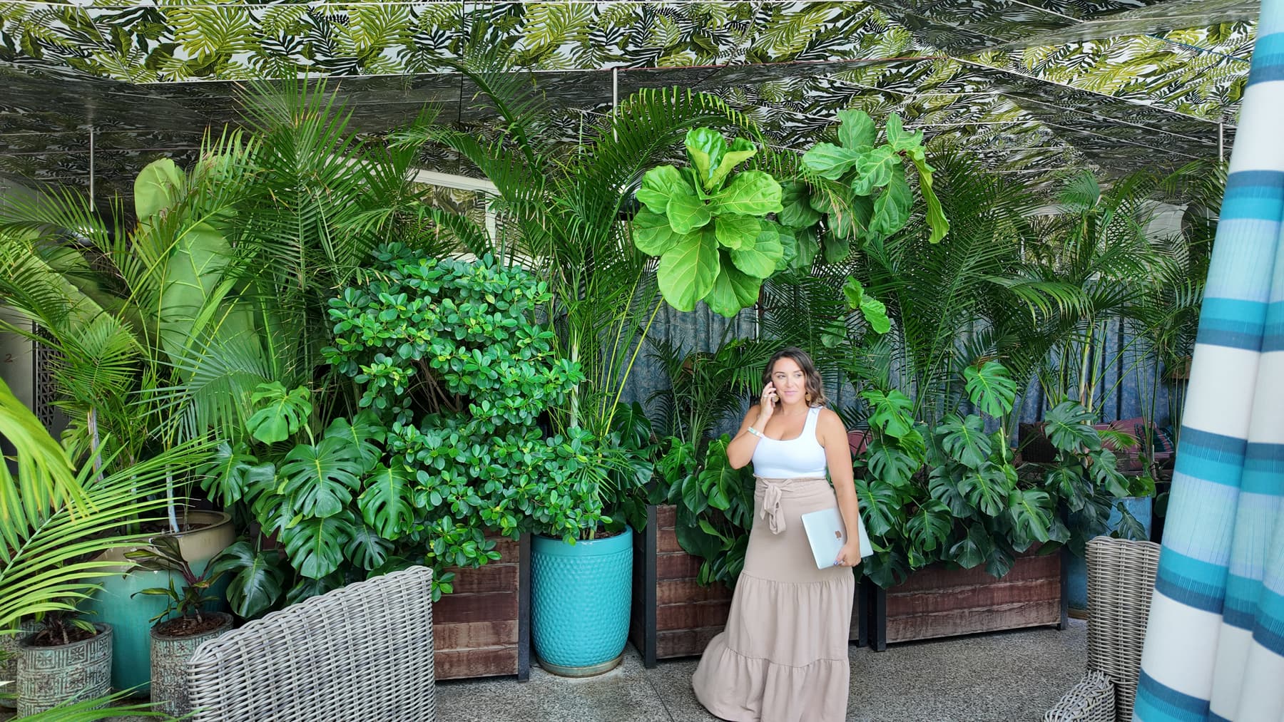Melody Estrada working outdoors surrounded by tropical greenery