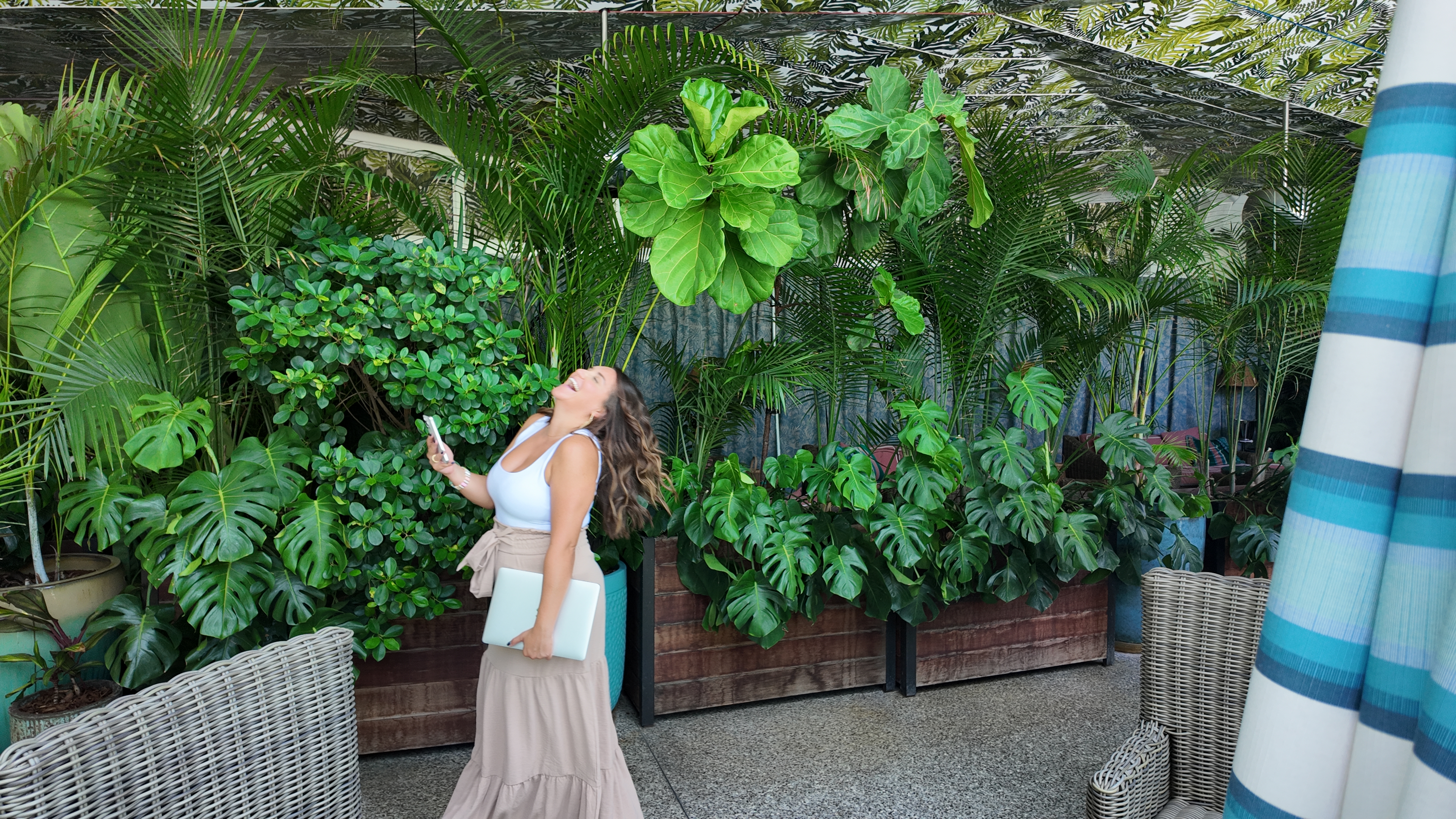 Melody Estrada laughing, surrounded by tropical greenery
